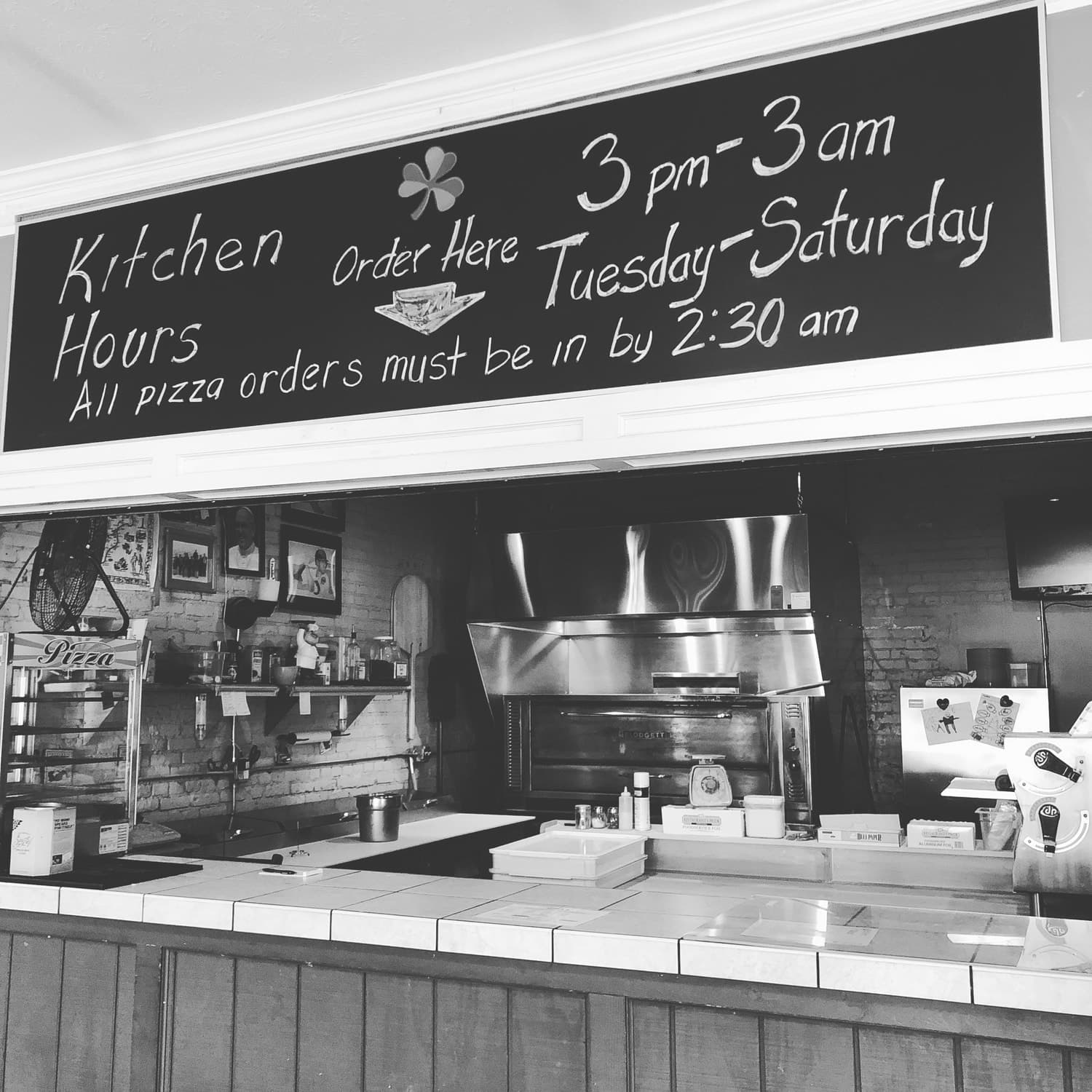 The pizza kitchen chalkboard listing kitchen hours